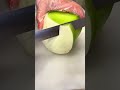 Peeling and slicing a fresh green melon on a white cutting board with a small sharp kitchen knife