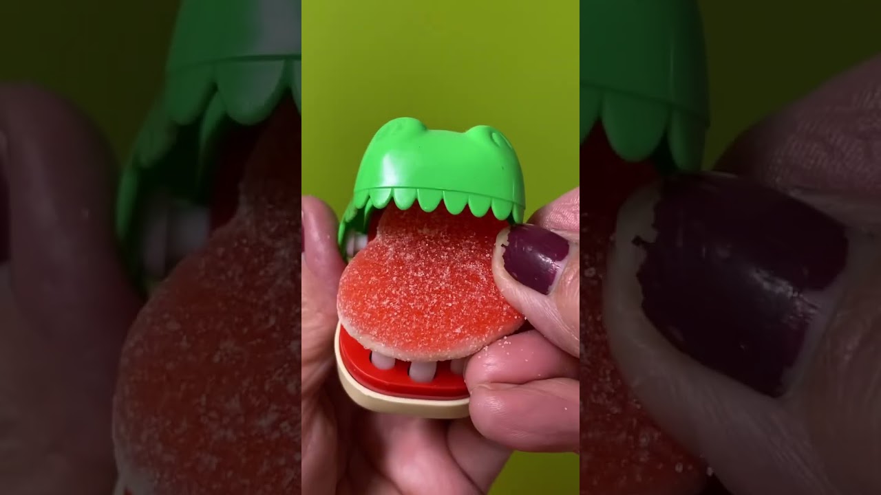 The cute green dinosaur want to eat big heart gummy candy 