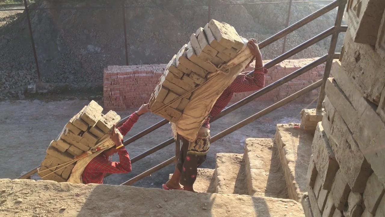 Three Men Carrying Bricks On Their Head, From The Back, In A Fine Art