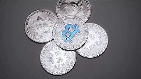Cryptocurrency, Silver Bitcoins Rotating on the Grey Background