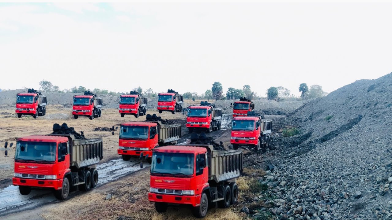 A view of a truck transporting rocks from a pond that has been blasted ...