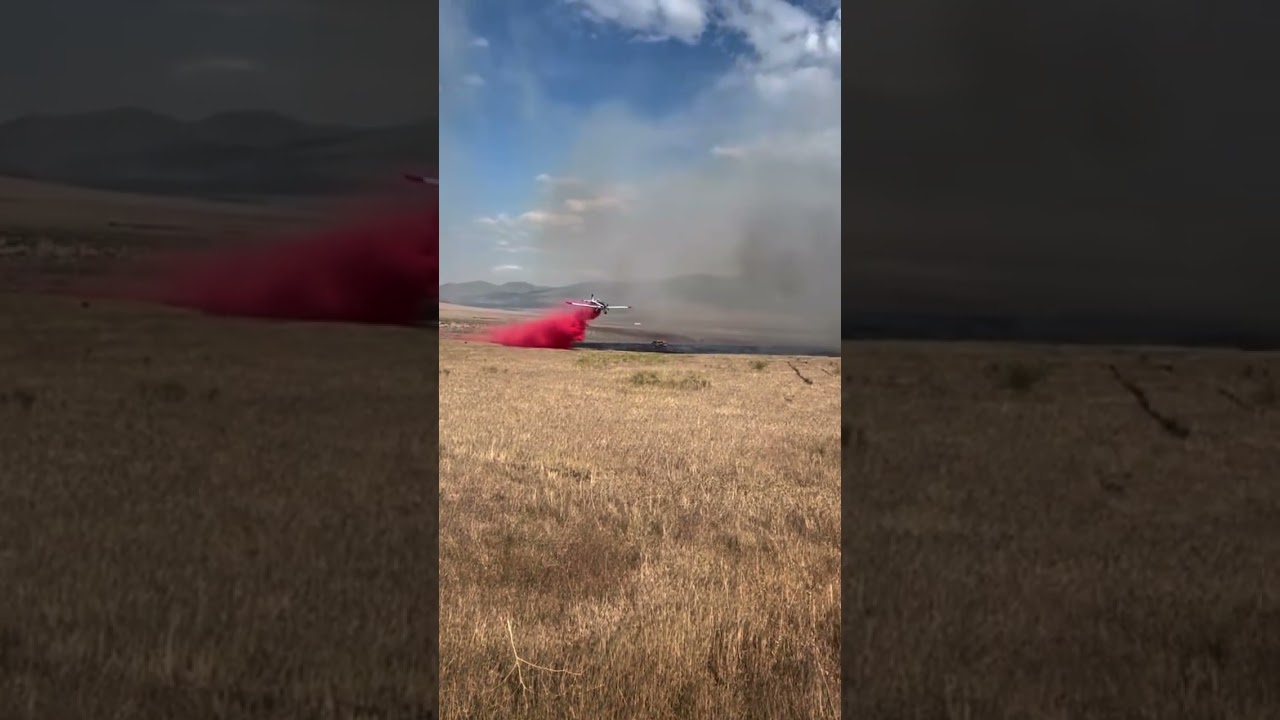 Single engine air tanker drops retardant on a wildfire.  