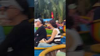 Man Styling While Riding in a Coconut Boat as Tourists Watch