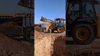 JCB 3CX LOADING SAND IN TRACTOR