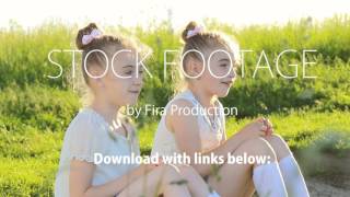 Two little girls sitting on grass talking have fun