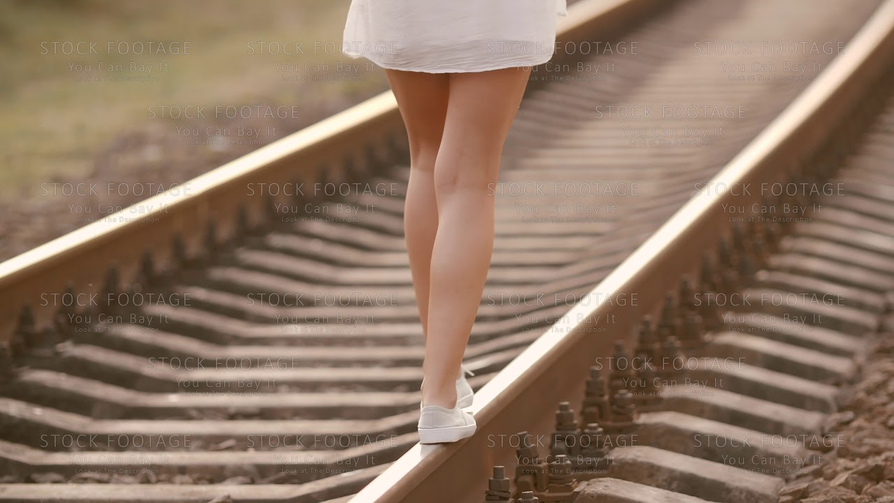 Woman balancing on train rail. Beauty, freedom, summer travel concept ...