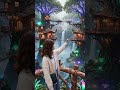Avatar-inspired tree house village built high above the jungle canopy on massive glowing trees,