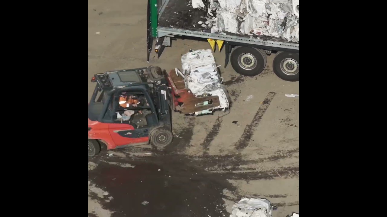 Fork Lift Truck unloading a truck load of baled scrap metal of white goods for recycling 