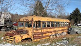 Abandoned vehicles in America: old cars, rusty tractors. Abandoned bus.