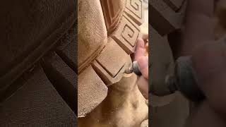 carving intricate patterns on wood using a power rotary tool to create a detailed artistic design