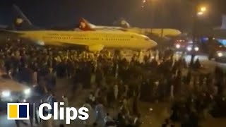 Fleeing Afghans pack tarmac at Kabul airport as Taliban takes control of the capital