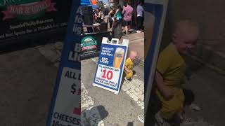 Boy bumps head on beer sign outside of bar
