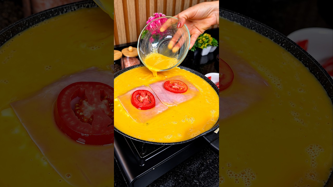 Omelet sandwich with ham, cheese, and tomato