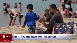 Neighbors flock to Holland State Park to beat the heat as West Michigan temperatures soar