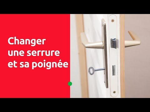 Un homme retire l'ancienne serrure de porte. À l'aide d'un