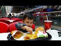 Boy eating a big burger with a cutlet in Burger King for toddlers. Delicious and satisfying.