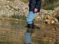 Black wellies in water and mud in gravel pit