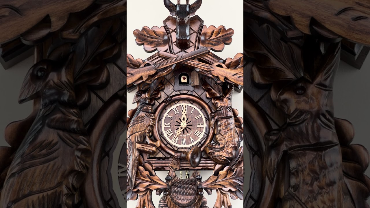 819-20 20" 8 Day Hunter's Cuckoo w/ Hand carved Oak Leaves, Animals, Rifles & Buck closeup at 