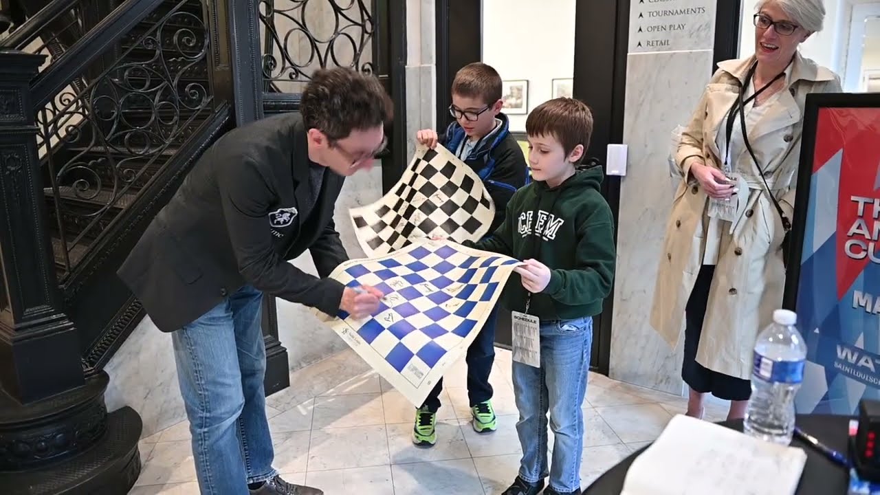 Fabiano Caruana signs autographs for young fans after his day one win at American Cup