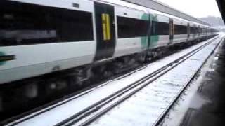 A snowy Southern train pulling out of Haywards heath With Sparks