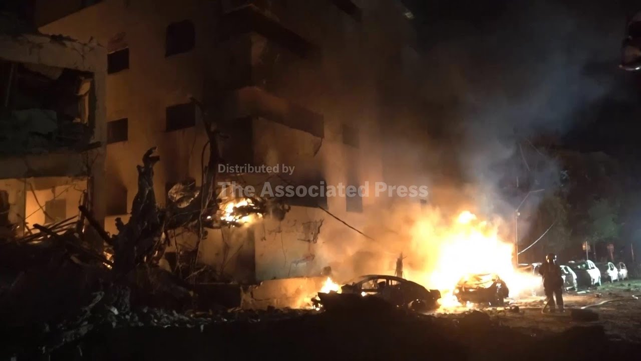 Cars on fire as Israeli emergency services respond to projectile hit amid Iran retaliation