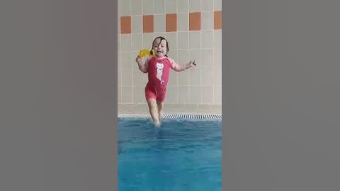 Малышка прыгает в бассейн.