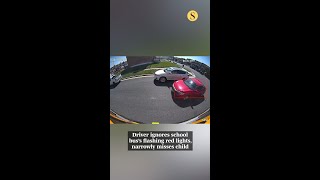 Driver ignores school bus's flashing red lights, narrowly misses child