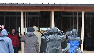 Amish and local volunteers sing "How Great Thou Art" after moving Mike Kinsey's garage by hand