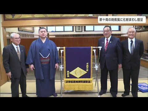 “小牛田農林”校章と“不撓不屈”の文字「新十両の時疾風」に化粧まわし贈呈「勝ち越し目指して頑張ります」