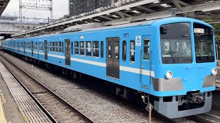 西武101系1251編成（近江鉄道100形カラー塗装）が回送電車として警笛を鳴らして小手指駅3番線を発車するシーン（2024.5.27.10:26）