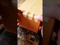 assembling two wooden boards with tight dovetail joints and inserting a small matching rectangular