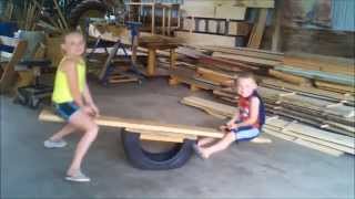 Grandkids on DIY Teeter Totter using a Used Tire and Hines Farm Sawmill Lumber.