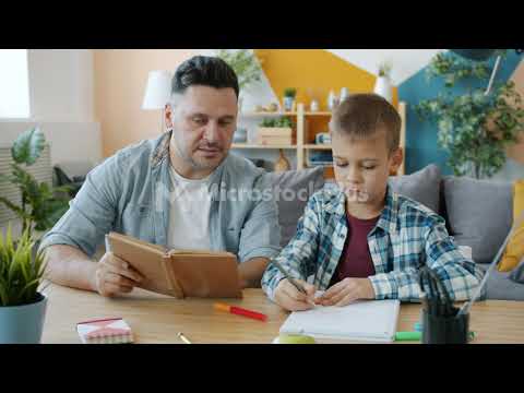 caring-dad-reading-book-to-kid-while-child-drawing-pictures-at-desk-in-apartment