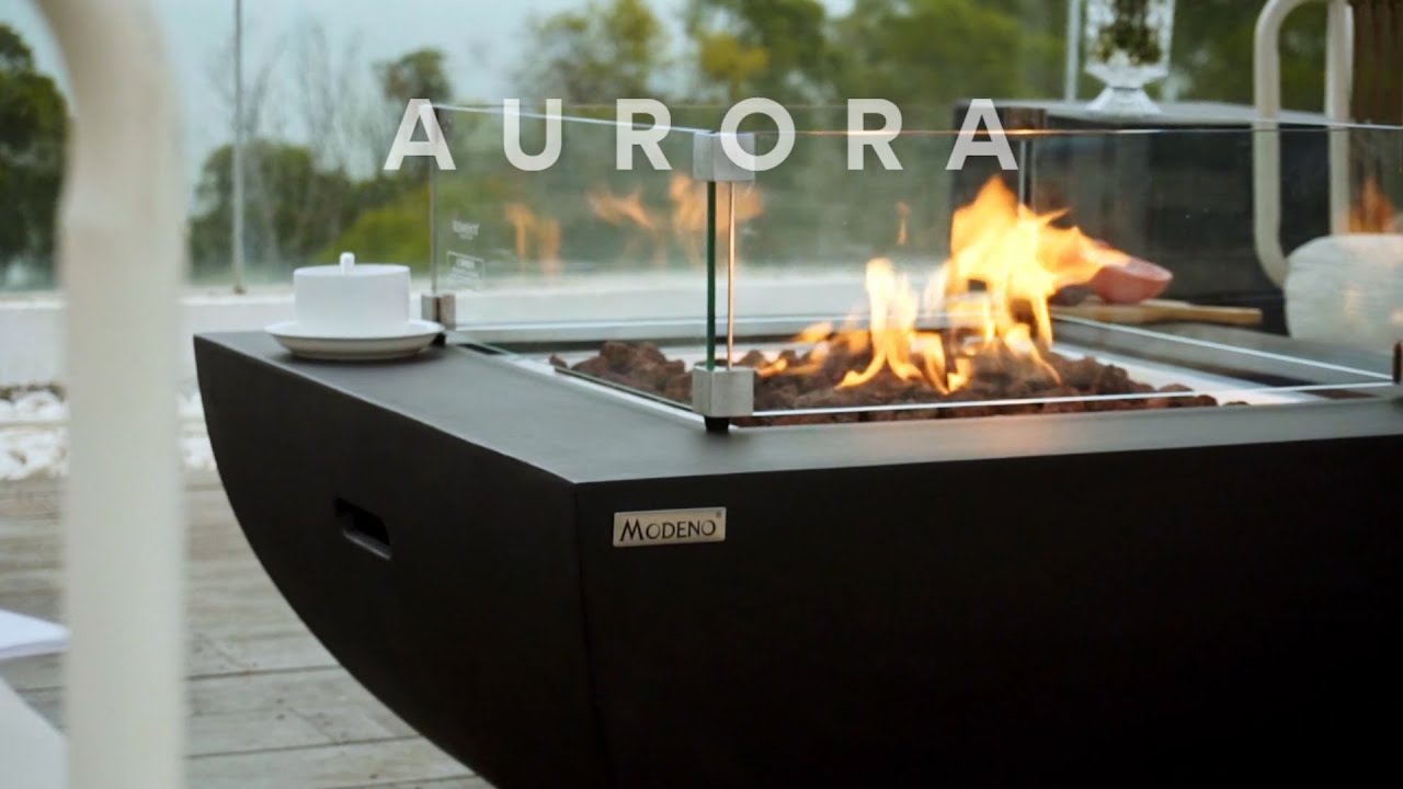 AURORA table with a lit fire pit on a terrace