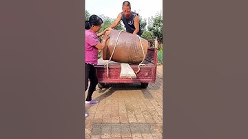 Unloading a pottery jar: people unloading a large pottery jar from a truck