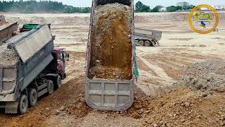 land construction with shantui dozer and dump trucks unloading soil