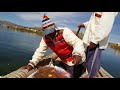 Expert fishing on totora grass boats lake titicaca uros floating islands  puno peru 