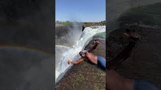 Man Poses With Rainbow Above Stunning Waterfall