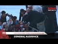 The Pope comes down from the altar to bless a child in a wheelchair