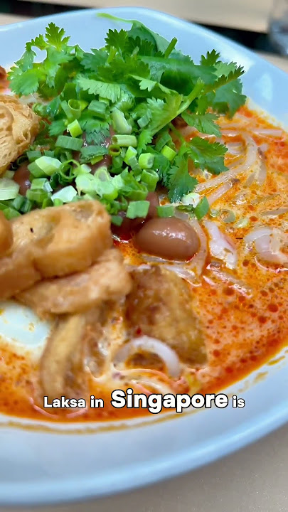 Laksa in Singapore is a beloved, spicy noodle soup.
