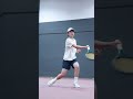 A 14-year-old tennis kid is training with the ball coming to the net in the middle and