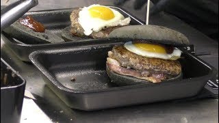 Master of BLACK BUN Burgers with Best Italian Meat, Eggs and Bacon. Street Food