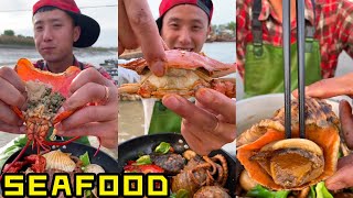 Pria tampan makan makanan laut yang lezat ikan octopathy, kepiting, abalon, kerang laut, udang,