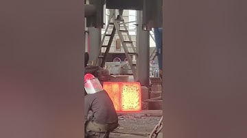 Dangerous forging, using heavy equipment to forge rectangular iron blocks at high temperatures