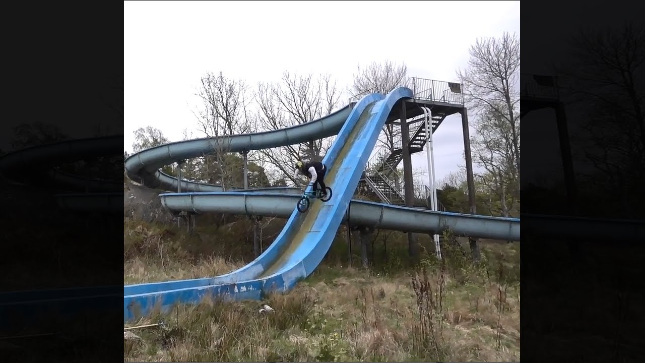 guy bikes down a tall water slide - guy bikes down a tall water slide. These guys are INSANE! I want to bring my bike to a water park now! It looks so fun!