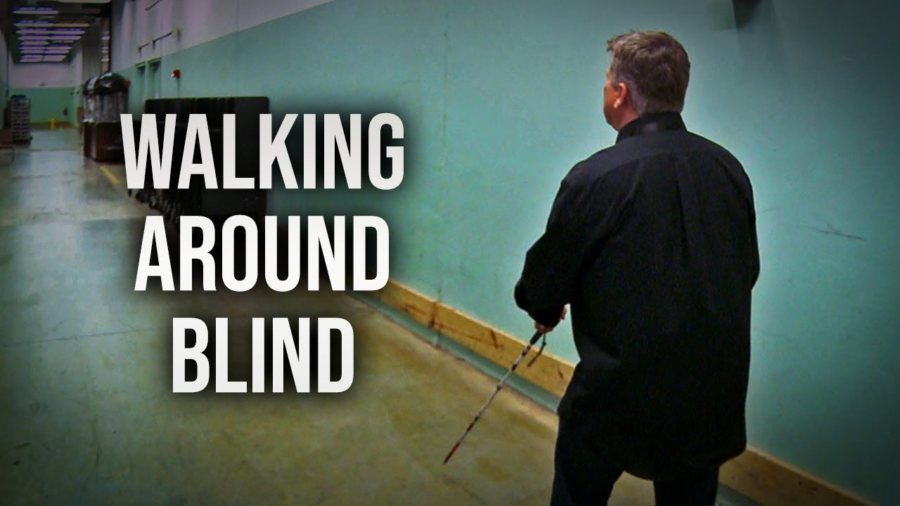 Following A Blind Person Walking Around Using A White Cane