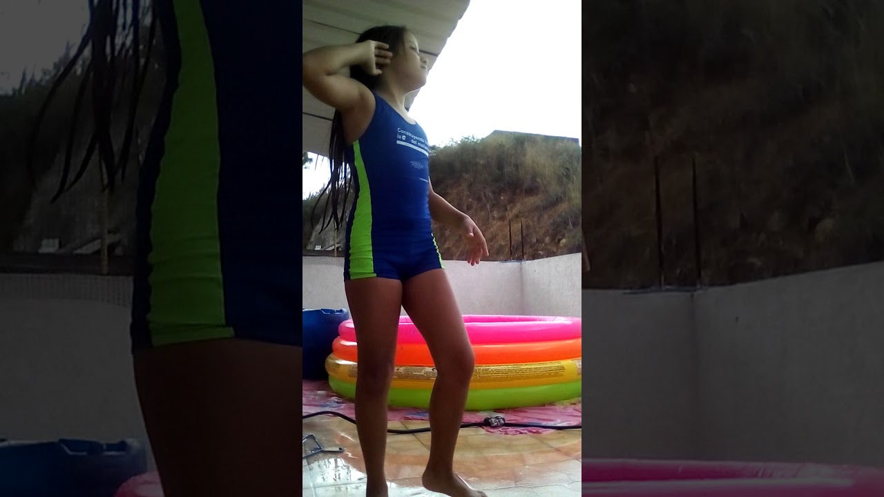 La niña está muy emocionada por nadar en la piscina con neumáticos de