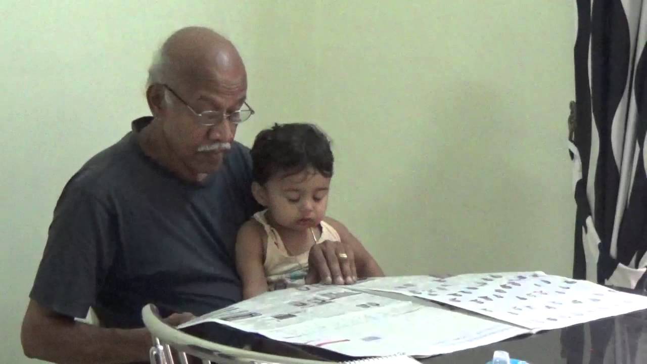 Grandpa granddaughter reading newspaper.