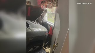 Crews work to remove a car from a building in Westbrook