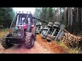 Full trailer of wood turned over, Belarus Mtz 892.2 forestry tractor  helps to get up